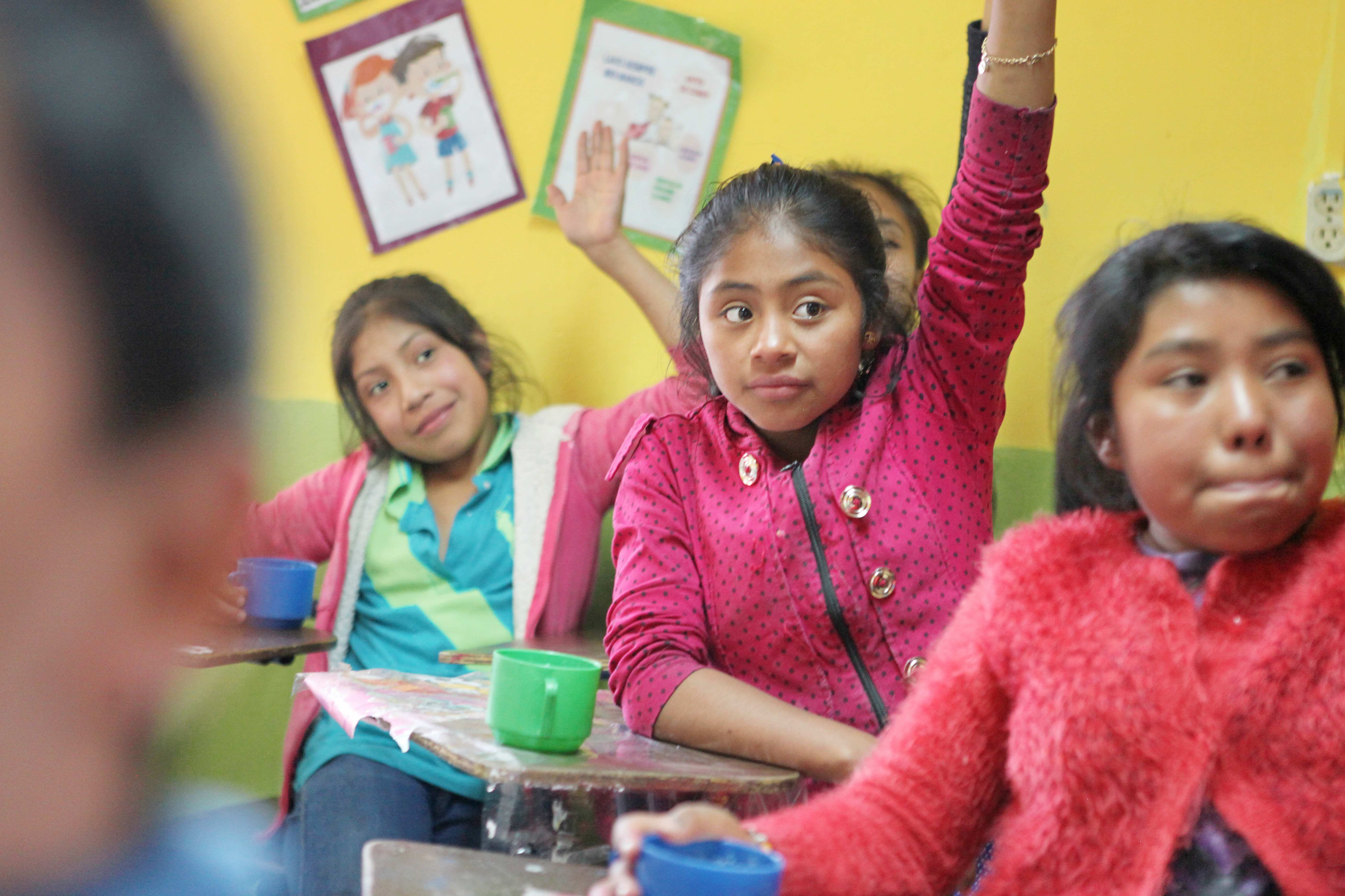 ACHTUNG: dies ist ein überarbeitetes Bild, verwendet in der Broschüre IMAGE Stand: 2018/11 (Albrecht)  Original siehe: ID KNH954580
Guatemala Action!Kidz Reise 2018 - Schulunterricht CEIPA School Markt  Schulklasse, Mädchen melden sich, Tisch, Lernen, Unterricht,