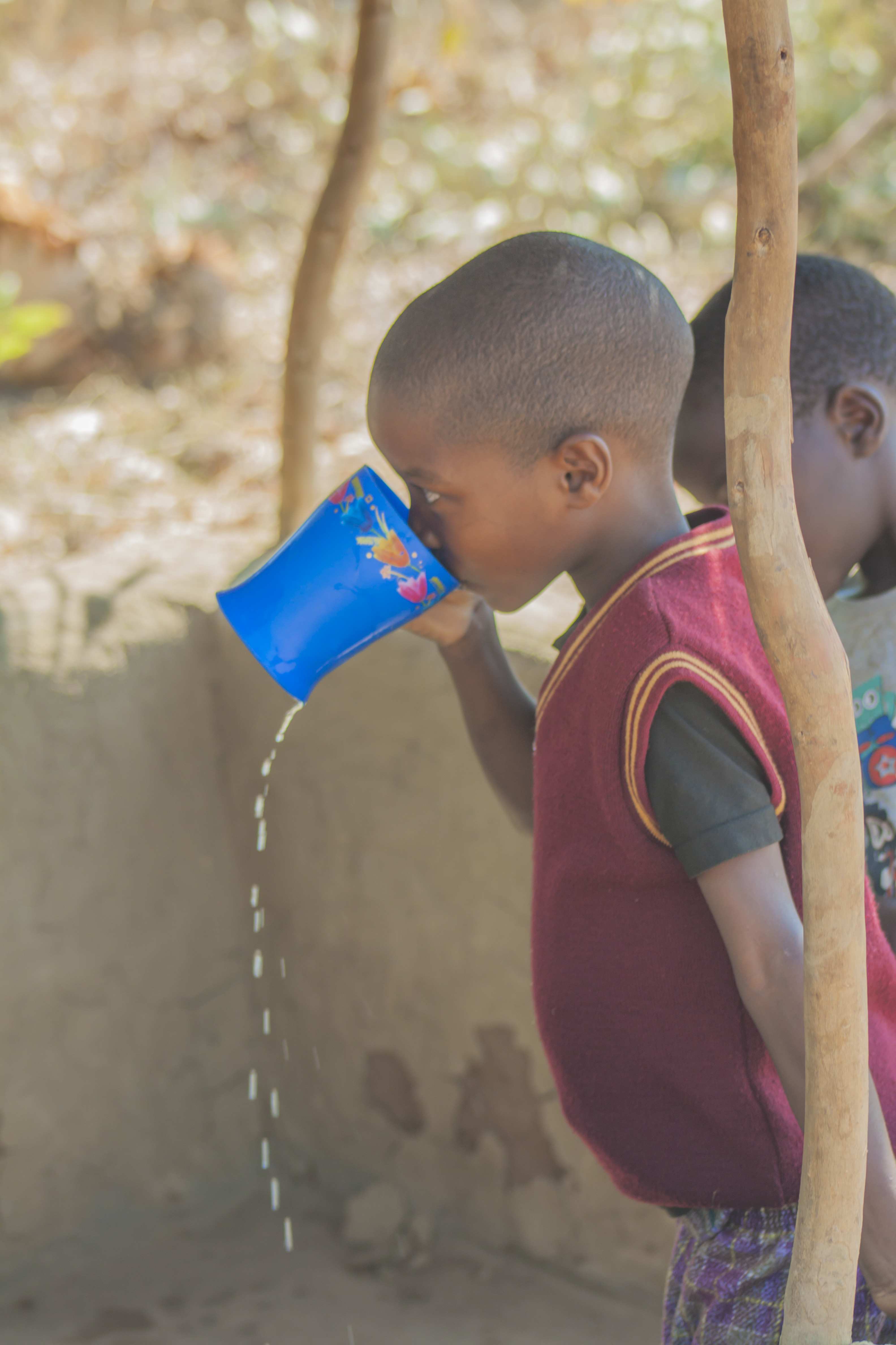 Junge trinkt aus Becher 