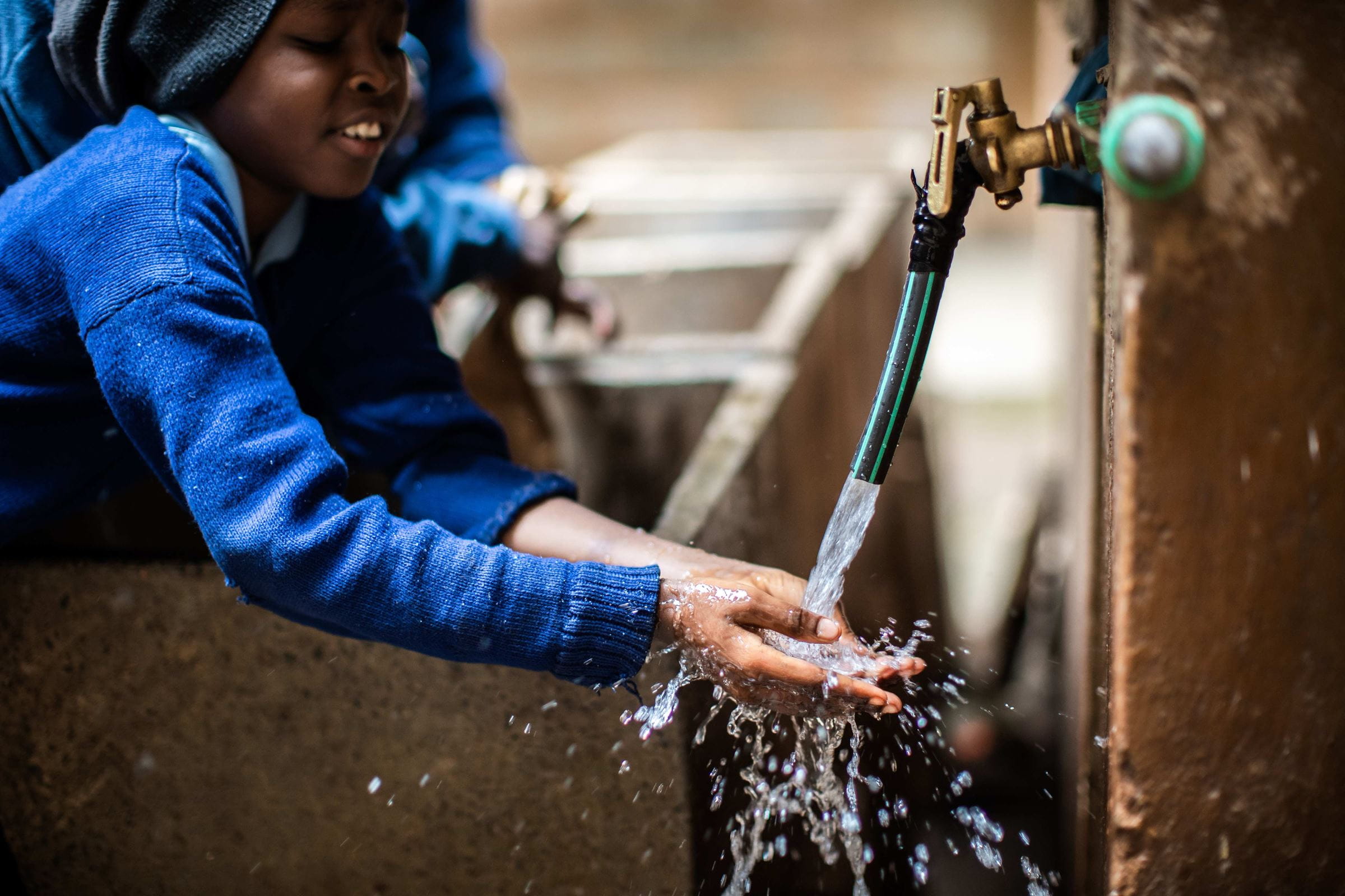 Kind wäscht Hände an Brunnen Kind wäscht Hände an Brunnen