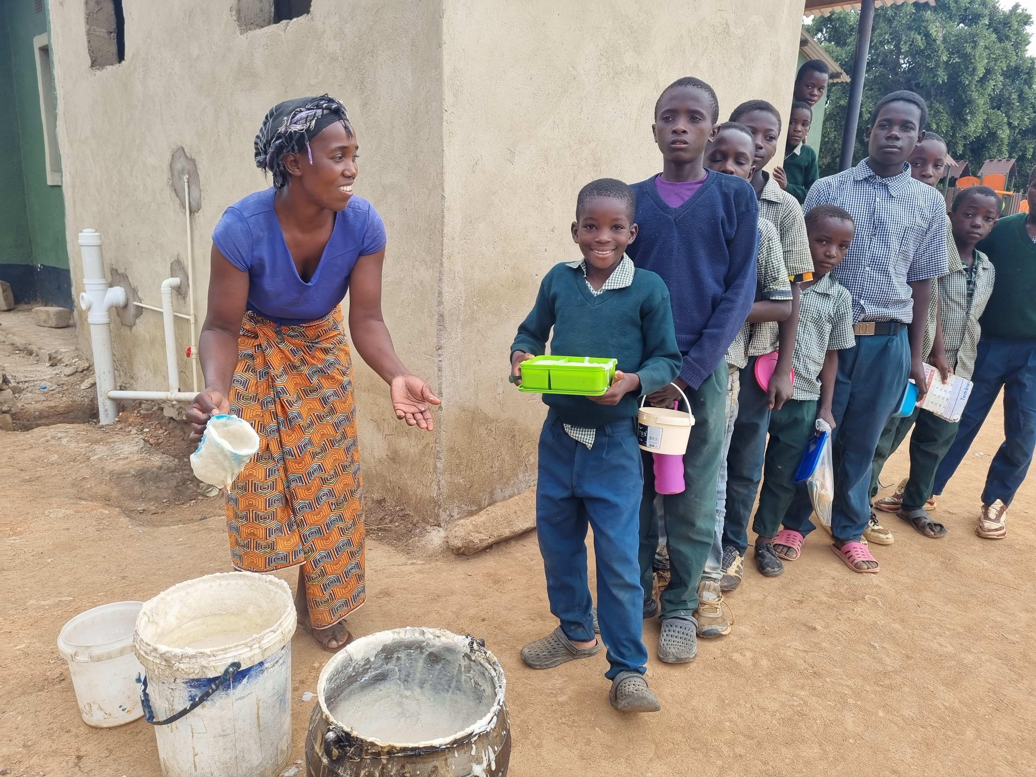 Kinder bekommen Frühstück in der Grundschule von Simunzele (Quelle: Kindernothilfe-Partner)