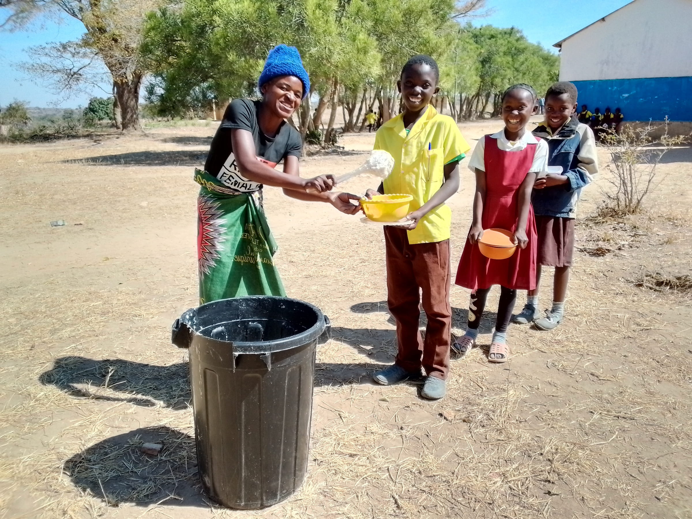 Pupils recieving porridge at Chisikili primary school 